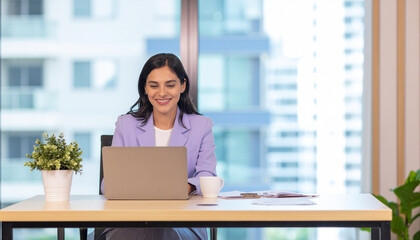 Bright office space with woman on laptop computer