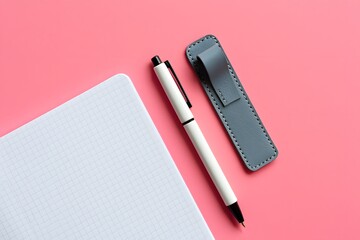 Stock photo of white pen and gray leather pen holder on pink background for office supplies shop