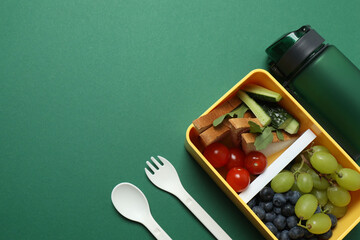 healthy lunch box with school backpack, apple and stationery on color background