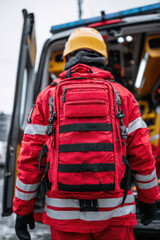 paramedical staff man holding red color backpack