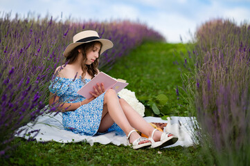 Girl reading book in lavender field. Peaceful summer day enjoying nature's beauty.