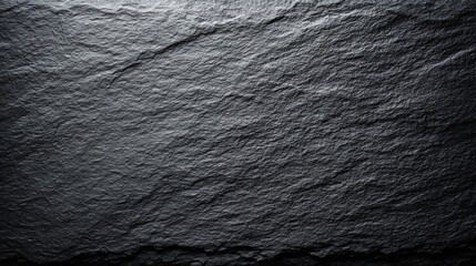 Close-up of textured dark gray stone surface with natural rugged pattern and subtle sheen.