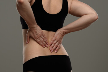 Fototapeta premium Woman in Black Outfit Experiencing Lower Back Pain