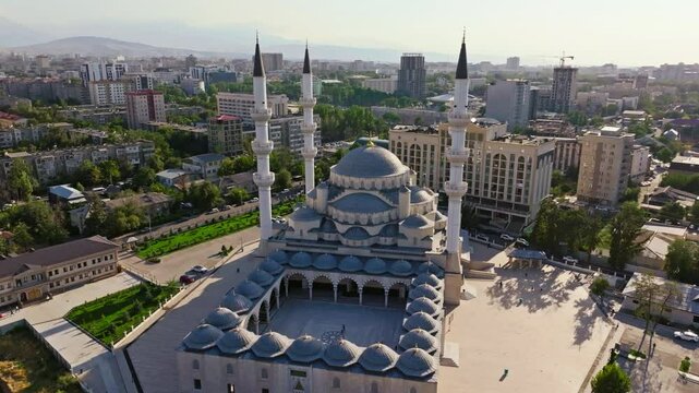 Aerial footage of Bishkek Central Mosque, also known as Turkish Mosque, in Bishkek, Kyrgyzstan during summer 2024. Features Islamic architecture, minarets, and surrounding urban area. Orbiting arc