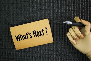 Pen and paper with word question What's Next? next step concept. coming immediately after the time...