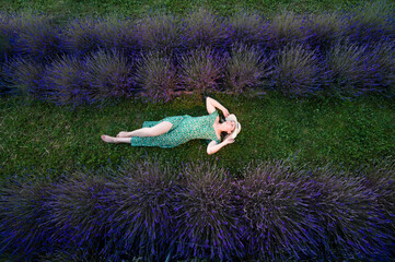 Woman relaxing in a lavender field. Peaceful summer scene.