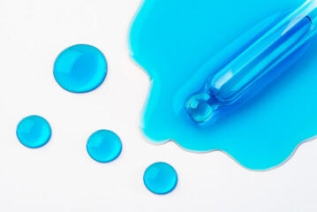 Drops of cosmetics and a pipette on a white background. A product for skin, face or hair care.