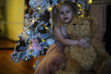 5 years old little girl decorating Christmas tree at home