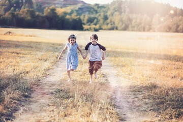 Children walk in the park in autumn. Child outdoors on a sunny summer morning in the park.
