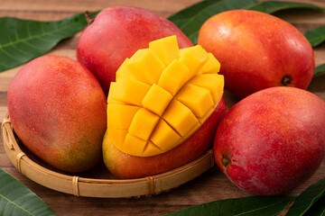 Fresh ripe mango with cubes on wooden table background.