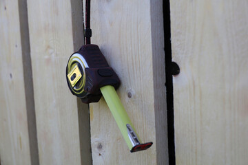 A measuring tape hangs on a wooden wall. House construction and renovation