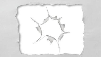 Abstract starburst hole torn through white paper with soft shadows