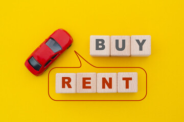 For Buy or Rent property concept, top view of wooden cube blocks with text and red car on yellow background
