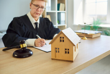 Judge woman in professional outfit black robe writing reviewing house jurisprudence documents in...