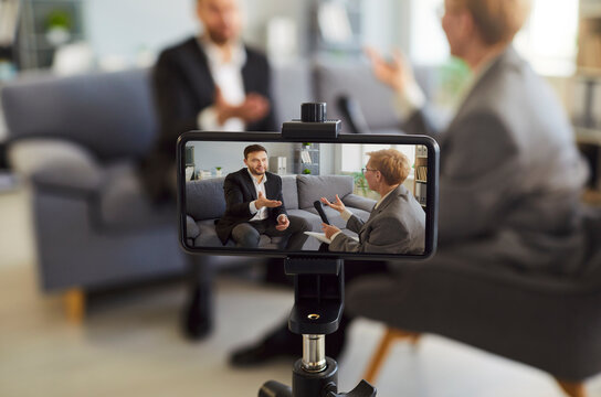 Smartphone screen showing blogger woman speaking using professional microphone, taking video for blog, radio host, speaker holding program air broadcasting, recording audio, webinar training, lecture 