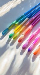 Colorful paintbrushes arranged on a light surface, angled, showing vibrant hues and soft shadows
