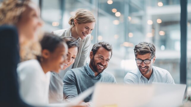 Group of diverse young adults working collaboratively in modern bright office space.