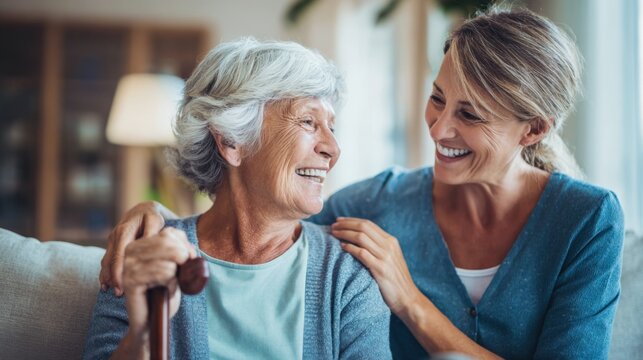 Elderly woman and young caregiver sharing joyful moment indoors in cozy home setting.