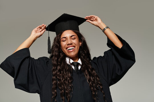 Graduating student beams with joy in a stylish cap and gown in a bright setting