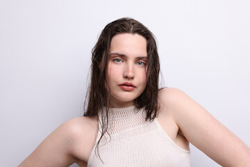 Portrait of beautiful woman with natural skin complexion on light grey background, closeup