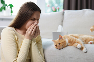 Woman suffering from allergy with her cat at home