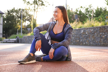 Happy woman in sportswear at stadium. Healthy lifestyle