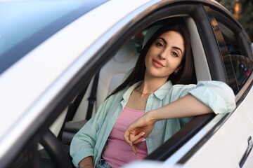 Woman sitting in modern car, view from outside