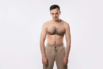 Fototapeta premium Man with incorrect posture posing on light grey background