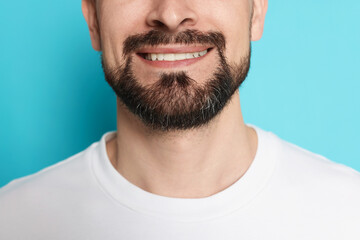 Fototapeta premium Smiling man before shaving on light blue background, closeup