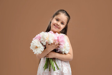 Cute little girl with bouquet of beautiful peonies on brown background