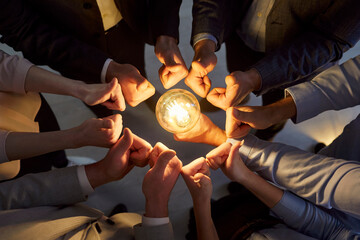 Top view of business people group joining hands in a circle showing thumb up sign holding...
