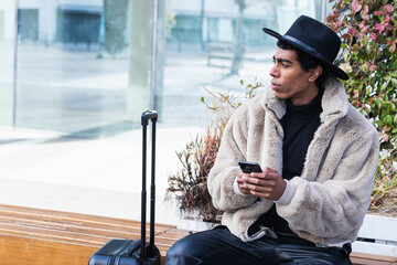 Stylish black man using smartphone outdoors