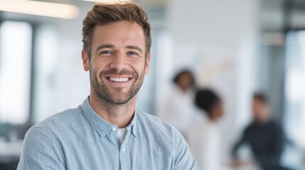 Obraz premium Friendly smiling man in casual shirt standing in modern office environment with colleagues.