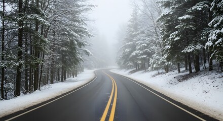 A winding road cuts through a snowcovered forest on a foggy winter day, creating a scenic and atmospheric landscape