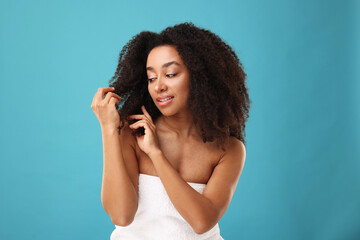 Fototapeta premium Portrait of beautiful Brazilian woman after spa treatment on light blue background