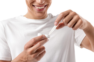 Man taking contact lens out of case on white background, closeup