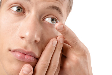 Man putting in contact lens on white background, closeup