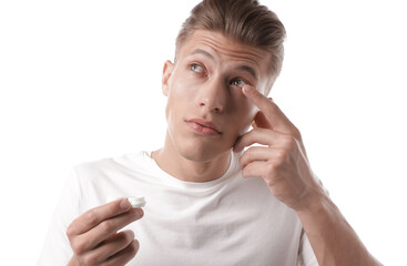 Man putting in contact lenses on white background