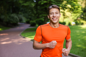 Sporty man running in park, space for text