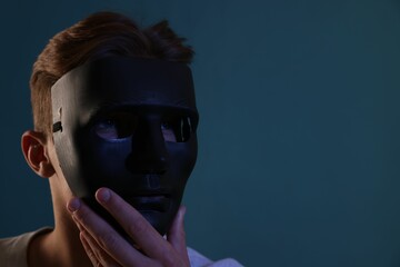 Anonymity. Man wearing mask on blue background, space for text