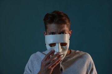 Anonymity. Man wearing mask on blue background
