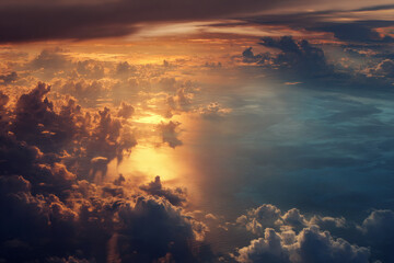 Dramatic sunset sky with golden clouds reflecting on the ocean surface from above
