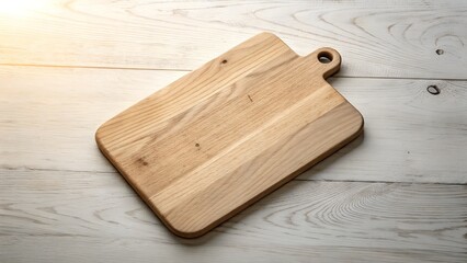 Fototapeta premium A clean natural wood cutting board with a rounded handle rests on a rustic weathered white wooden surface with sunlight streaming from the left