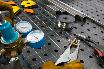 gas equipment pressure gauge close-up, metal welding table in the background