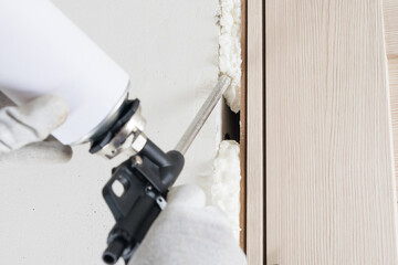 close-up of a gun for sealing and sealing a doorway, mounting foam
