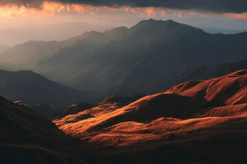 Naklejka premium Golden hour sunlight illuminates rolling hills and distant mountain ranges