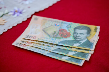 five 200 Romanian lei banknotes on a table