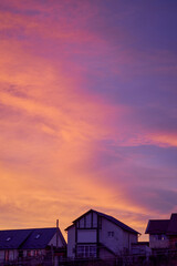landscape with a reddish sky above some houses at sunset
