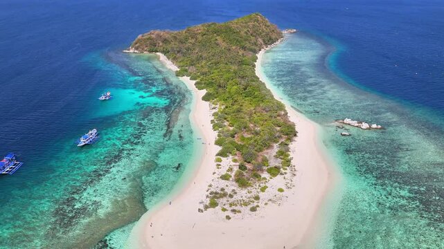 Aerial view of Manlihan Island in Linapacan, Philippines featuring white sand beaches, clear turquoise waters, coral reefs, and lush green foliage surrounded by traditional boats and shallow reefs