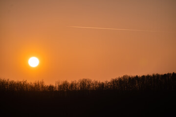 The sun visible to the naked eye. Astronomical phenomenon captured at sunset over the forest